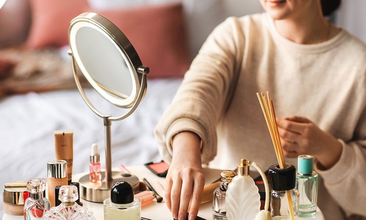 woman doing her makeup on a cosmetic mirror